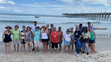 a group of happy active adults enjoying the beach at Surf City