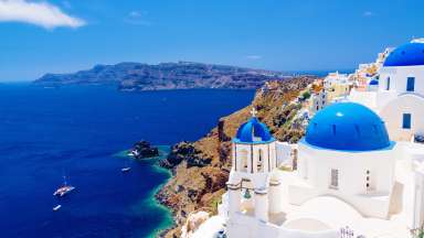 White architecture and churches with blue domes, Oia, Santorini, Greece