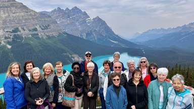 group of people in front of a pretty lake