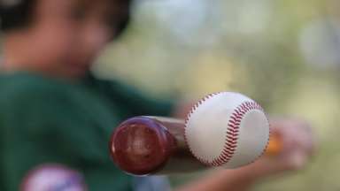 a boy hitting a baseball with a bat