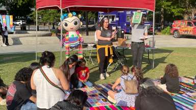 a group of children and caregivers enjoying story time at Moore square
