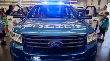 a Raleigh Police vehicle with children looking in it