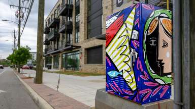 Photo featuring a mural on a signal box on street downtown