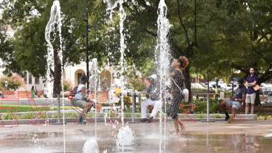 kids playing in a water feature in a park