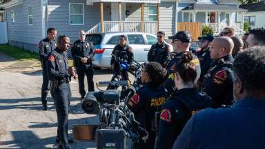 Raleigh officers gather in a neighborhood before the Cops on the Block event.