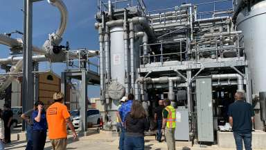 Group of people talking on a tour of the bioenergy facility