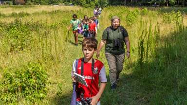 a group with binoculars hiking on a trail at Wilkerson nature preserve