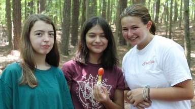 a group of three teens smiling