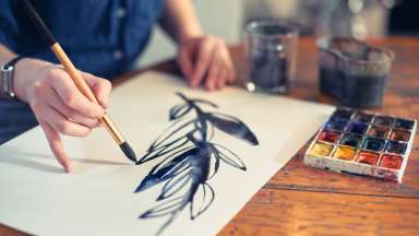 a person painting with a brush and watercolor