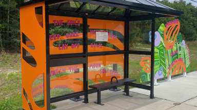 Colorful artwork installed behind and beside bus shelter