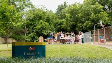 Image of Caraleigh Park sign and group of people gathered in the park