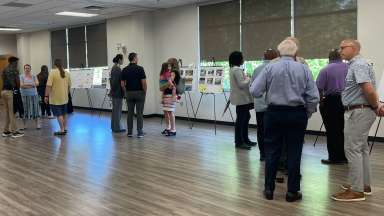 a group of people reviewing display boards at Marsh Creek community center