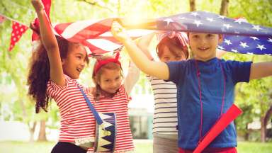 happy children playing with red, white and blue flags