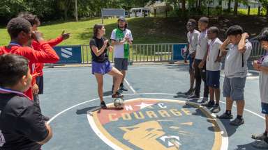 youth standing in a circle listening to their futsal coach