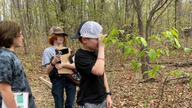 campers in the forest exploring with binoculars