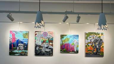 Colorful paintings hanging on a wall behind a front desk