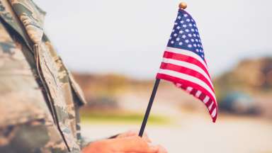 a soldier holding a mini american flag