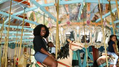 a person with a kid on a carousel