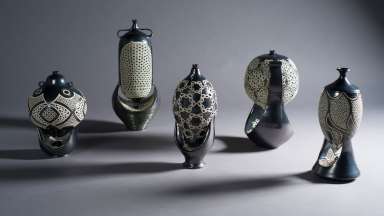 Five black and white intricately carved ceramic vases