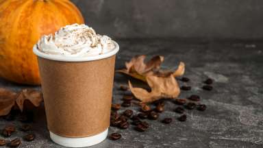 Pumpkin spice latte on table decorated with fall decorations