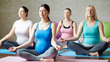 several people practicing yoga in gym