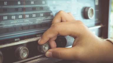 hand adjusting the button vintage radio receiver