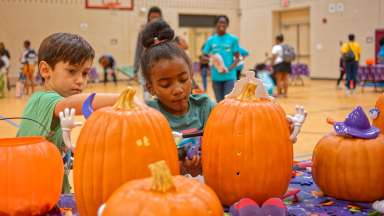 kids doing crafts on a pumpkin