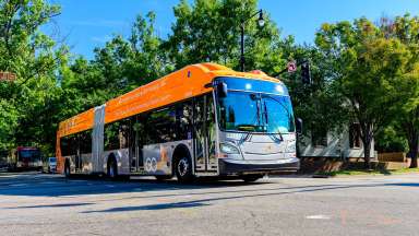 Bus Rapid Transit orange accordion bus rolling through downtown Raleigh