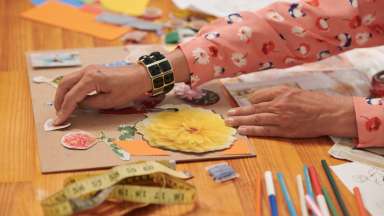 a person adding items to a scrapbook
