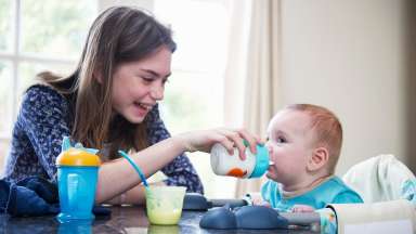a girl babysitting a baby