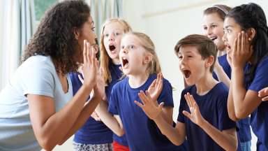 a group of kids with a teacher for theatre class