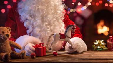 Santa at a table with gifts and toys