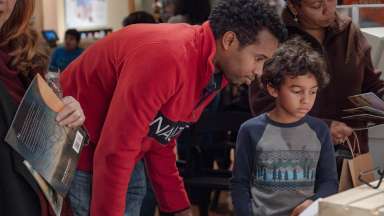 a kid and dad looking at books