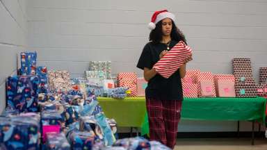 a girl in a santa hat holding a christmas gift