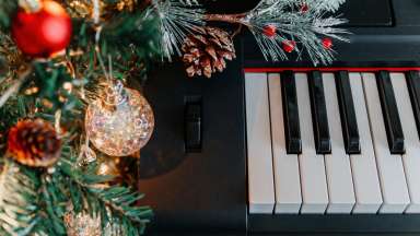 branches of a decorated holiday tree on the background of piano keys
