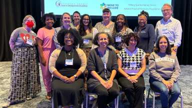 Community members lined up in three rows in front of presentation