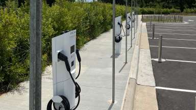 A row of electric vehicle chargers in a parking lot at Dix park.