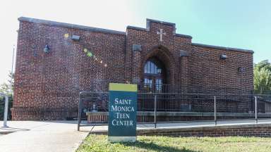 an image of a building with a sign out front labeled Saint Monica's Teen Center