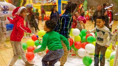children jumping and playing with holiday ballons
