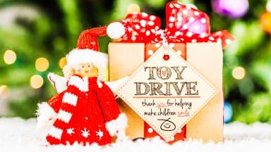 an elf with toy drive sign