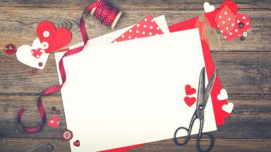 A vintage scrapbooking background with Valentine theme. With cutout hearts, skeleton leaves, craft paper, ribbon and buttons