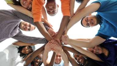various people hold their hands towards the center