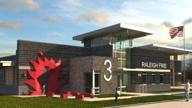 A large red sculpture is in front of a fire station labeled number 3
