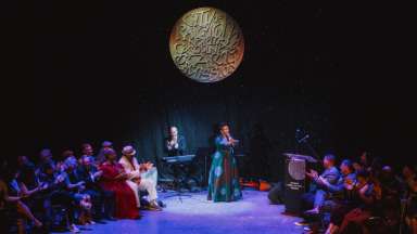 Performance with a woman signing on a stage.