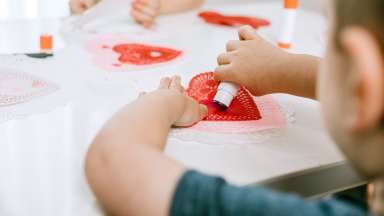 a child making heart shaped Valentine cards