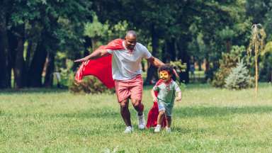 a dad and child pretending to be superhero