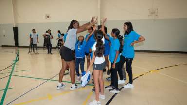 Coach giving players in a huddle a high five