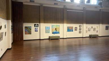 Colorful paintings hanging on white walls in a large room