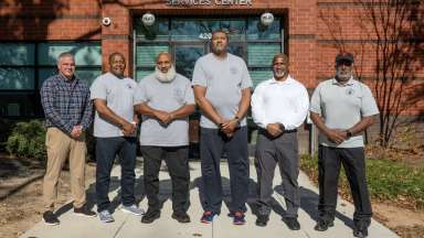 Youth mentors standing in front of brick building