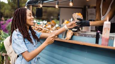a woman getting food from a truck